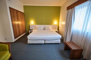 a hotel room with a large bed and a window at Hotel Varandas do Atlântico by RIDAN Hotels in Praia da Vitória
