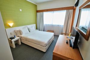 a hotel room with a bed and a television at Hotel Varandas do Atlântico by RIDAN Hotels in Praia da Vitória