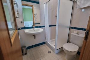 a bathroom with a toilet and a sink and a shower at Hotel Varandas do Atlântico by RIDAN Hotels in Praia da Vitória
