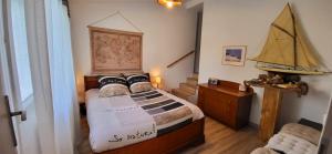 a bedroom with a bed with a boat on the wall at Le doux Sin in Habas