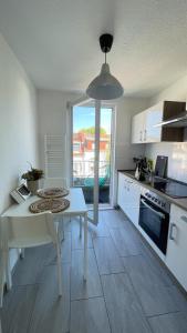 une cuisine avec une table blanche et une cuisine avec vue dans l'établissement Air Apartments 4, à Brême