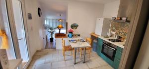a kitchen with a small table and a kitchen with a stove at Le doux Sin in Habas +13 photos