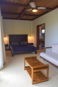 um quarto com uma cama, uma mesa e um sofá em Villa Elemental em Marau