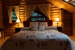 a bedroom with a large bed in a log cabin at 7Hills Finnish Luxury Chalet by Ski Alure in Eptalofos