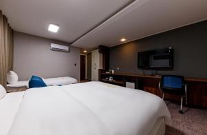 Habitación de hotel con cama grande y TV de pantalla plana. en Rex Hotel en Cheonan
