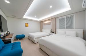 um quarto de hotel com duas camas e uma televisão em Rex Hotel em Cheonan