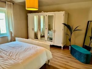 1 dormitorio con 1 cama y vestidor con espejo en Cascina Montè, en Guarene