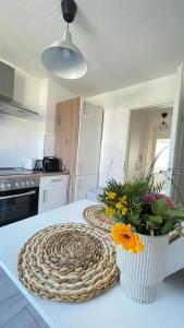 a vase of flowers on a counter in a kitchen at Air Apartments 5 in Bremen +3 photos