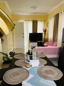 een woonkamer met een tafel met een fles champagne bij Clementine’s Subdivision House in Oroquieta