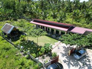 een huis met een auto ervoor geparkeerd bij CocoVille Guesthouse in Alegria