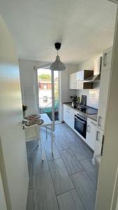 a kitchen with white cabinets and a table in it at Air Apartments 5 in Bremen