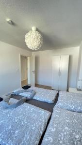 two beds in a bedroom with a chandelier at Air Apartments 5 in Bremen