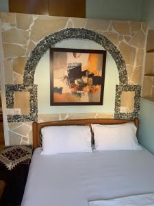 een slaapkamer met een bed met een stenen muur bij BACI HOUSE in Limenas