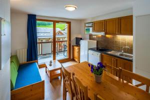 cocina y comedor con mesa de madera en Noemys Balcons de Bois Méan en Les Orres