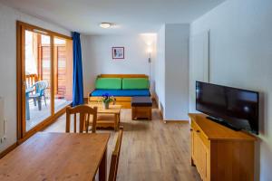 a living room with a room with a bed and a television at Noemys Balcons de Bois Méan in Les Orres