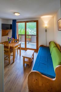 a bedroom with a bed and a table and a dining room at Noemys Balcons de Bois Méan in Les Orres