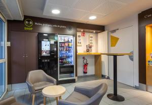 a waiting room with a soda machine and chairs at B&B HOTEL CHARTRES Le Forum in Chartres