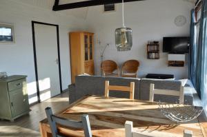 a living room with a couch and a table and chairs at Boerenslag 45 in Sint Maartensvlotbrug