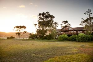 a large house with a large field in front of it at Oyster Creek Lodge in Knysna