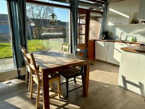 a kitchen with a wooden table and chairs in a kitchen at Boerenslag 45 in Sint Maartensvlotbrug