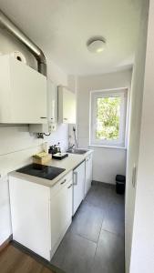 une cuisine avec des placards blancs et une fenêtre dans l'établissement Air Apartments 10, à Brême
