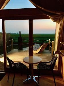 a balcony with a table and two chairs and a view at Lushna 12 Lux at Lee Wick Farm Cottages & Glamping in Clacton-on-Sea