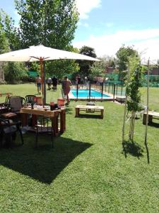 una mesa de picnic con una sombrilla junto a una piscina en Familia Tejada, en Mendoza