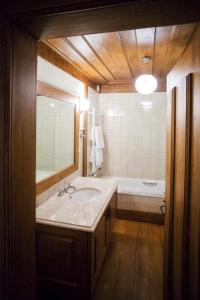 a bathroom with a sink and a tub and a mirror at Casa da Cerca in Mondim da Beira