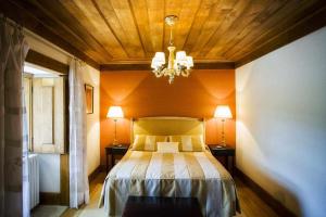 Schlafzimmer mit einem Bett mit Holzdecke in der Unterkunft Casa da Cerca in Mondim da Beira