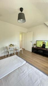 a white room with a bed and a table and a tv at Air Apartments 10 in Bremen