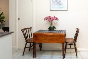 a table with two chairs and a vase of flowers on it at Bright & Contemporary 1bedroom Annexe - Herne Hill! in London