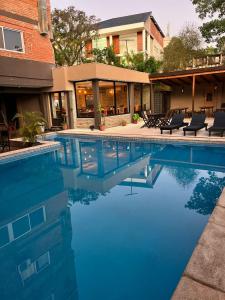 a swimming pool with chairs in front of a building at La Familia Hotel in Puerto Iguazú