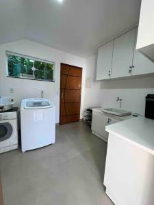 cocina con fregadero y lavadora en Extraordinária casa Ilha grande, en Angra dos Reis