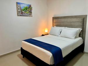 een slaapkamer met een groot bed en een blauwe deken bij Hostal Boutique Casa Pere in Cartagena