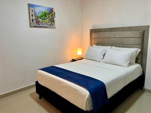 a bedroom with a large bed with a blue blanket at Hostal Boutique Casa Pere in Cartagena de Indias