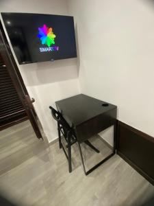 a small black table with a television on a wall at DALY home intero appartamento in Mugnano di Napoli