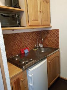 a kitchen with a sink and a stove at Studio 4 couchages Risoul cœur de la station in Risoul +1 photo