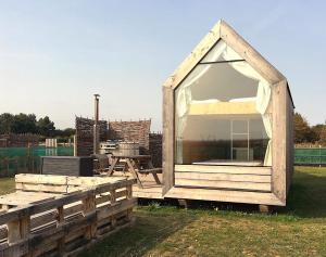 a wooden play house with a large window at Lushna 6 Petite at Lee Wick Farm Cottages & Glamping in Clacton-on-Sea