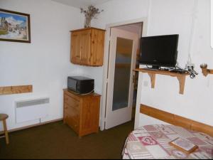a room with a bedroom with a bed and a television at Studio 4 couchages Risoul cœur de la station in Risoul