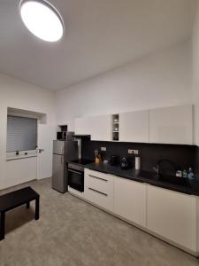 una cucina con armadi bianchi e piano di lavoro nero di Apartmány Přerov 22 a Přerov