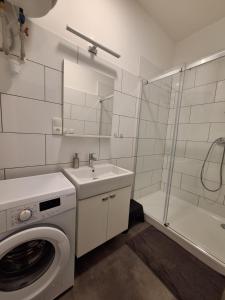 bagno bianco con lavatrice e lavandino di Apartmány Přerov 22 a Přerov