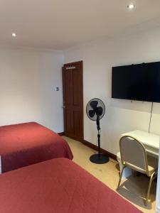 a hotel room with two beds and a desk and a flat screen tv at Shared house on Southmead in Bristol