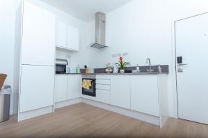 uma cozinha com armários brancos e um fogão em One bedroom serviced apartment Smethwick flat 310 em Birmingham