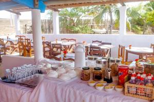 a table with jars of food and drinks on it at Pousada Jeri Flats in Jericoacoara