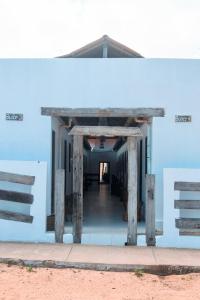 a building with a blue wall with a wooden structure at Pousada Jeri Flats in Jericoacoara