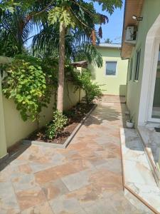 einen Innenhof mit einer Palme neben einem Gebäude in der Unterkunft Emron Homelodge in Accra