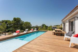 einen Pool mit Stühlen und eine Terrasse in der Unterkunft Villa Le Golf St Thomas 19 pers in Béziers