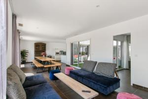ein Wohnzimmer mit Sofa und Tisch in der Unterkunft Villa Le Golf St Thomas 19 pers in Béziers