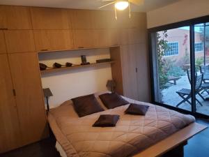 a bedroom with a large bed with a large window at Le Jardin des Copains in Canet +58 photos