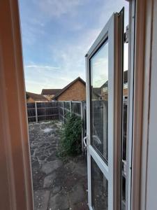 an open door to a patio with a yard at Exquisite Holiday Home 3 minutes from Dartford Station in Kent
